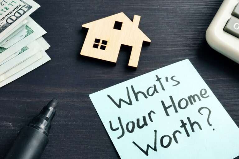 Home valuation note beside a wooden house model